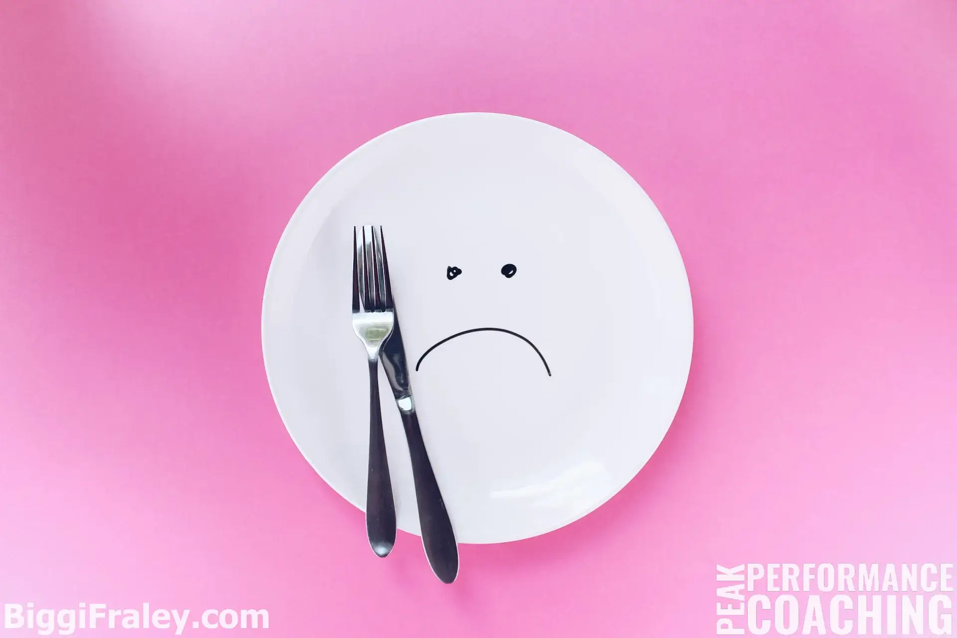 white plate with a frowning face marker drawing and silver knife and folk on plate