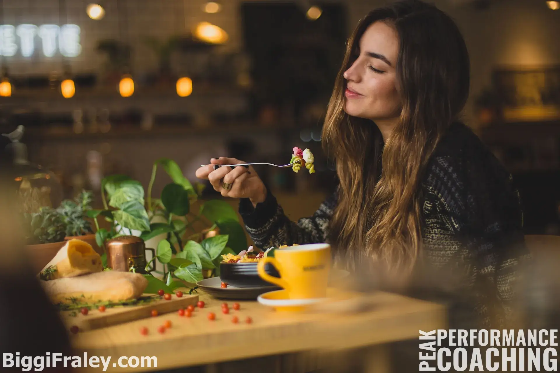 woman sitting at the table, fork in hand, clearly savoring her food